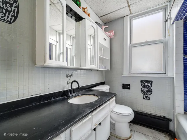 a bathroom with a granite countertop sink a toilet and a shower curtain