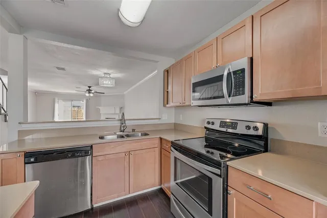 a kitchen with stainless steel appliances granite countertop a sink a stove microwave and cabinets