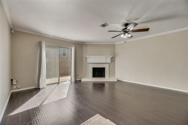 a view of an empty room with a fireplace and a window