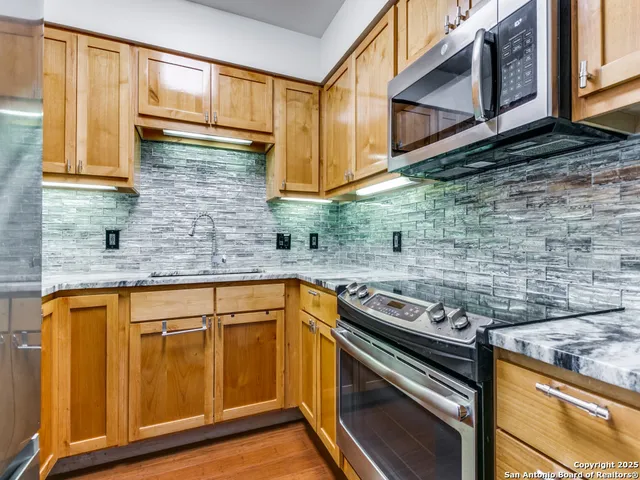 a kitchen with stainless steel appliances granite countertop a sink and cabinets