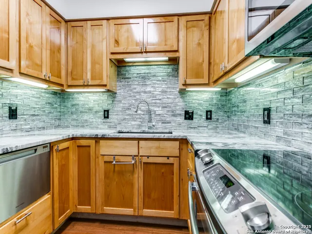 a kitchen with stainless steel appliances cabinets a large window and a sink