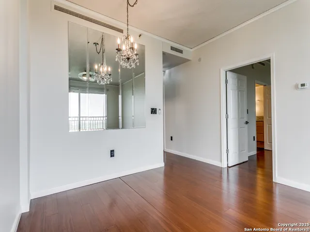 a view of a big room with wooden floor and windows