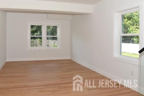 28 Plymouth Place Edison, NJ 08837 - Photo 12 of 33 a view of an empty room with wooden floor and a window