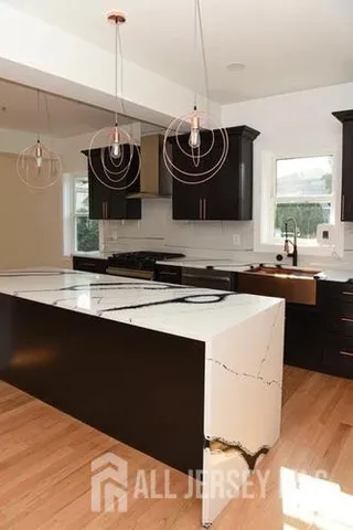 a kitchen with stainless steel appliances granite countertop a sink and a refrigerator