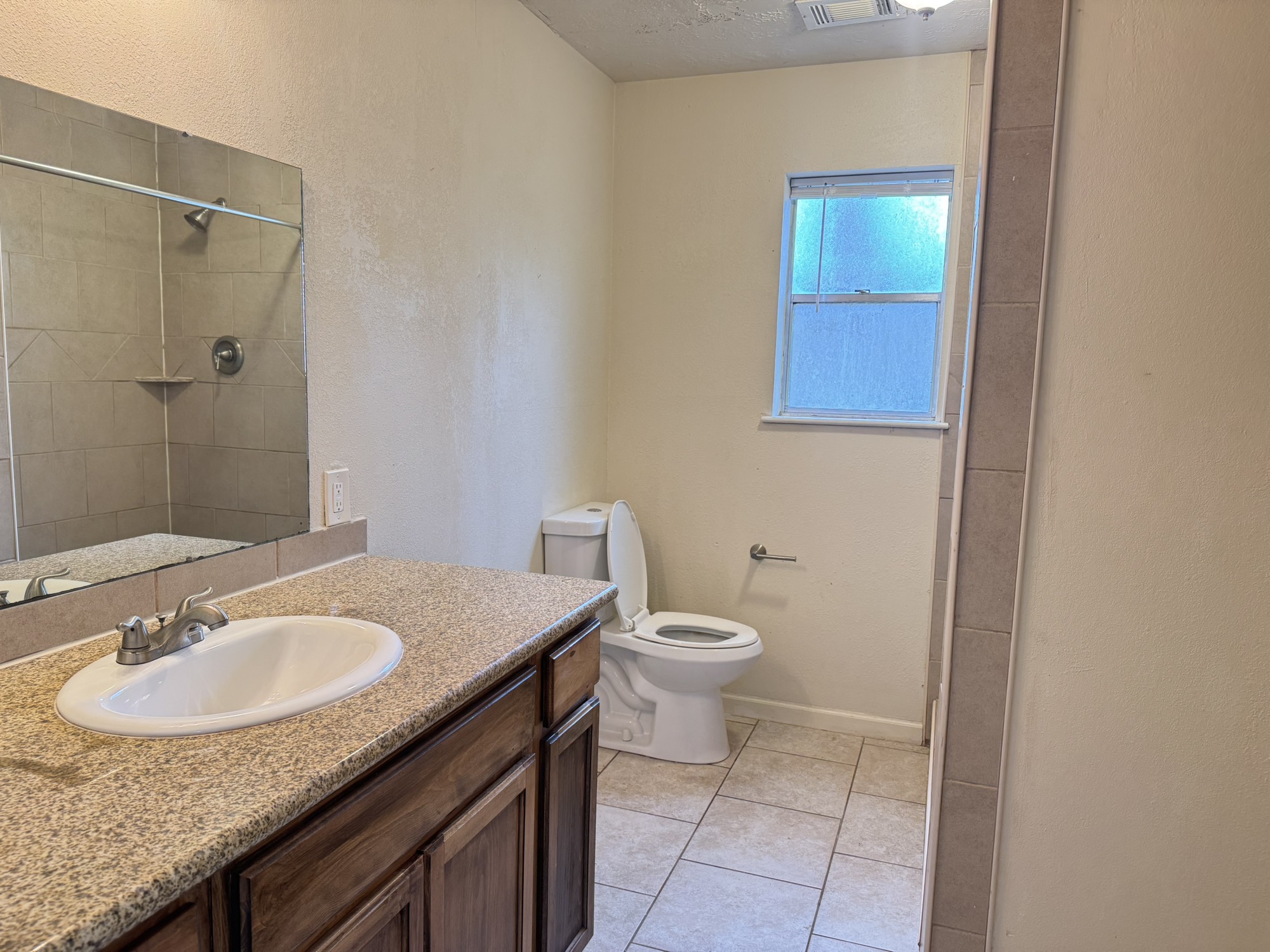 6214 Nowlin Drive Baytown, TX 77521 - Photo 12 of 12 a bathroom with a granite countertop sink a toilet a mirror and shower