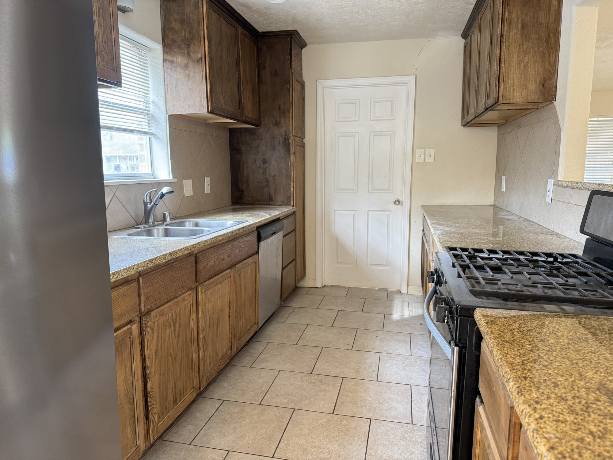 6214 Nowlin Drive Baytown, TX 77521 - Photo 6 of 12 a kitchen with stainless steel appliances granite countertop a sink stove and refrigerator
