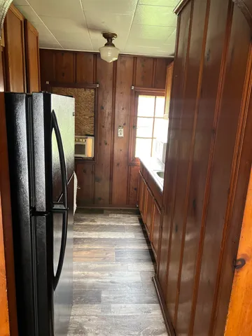 a view of a hallway with wooden door and stairs