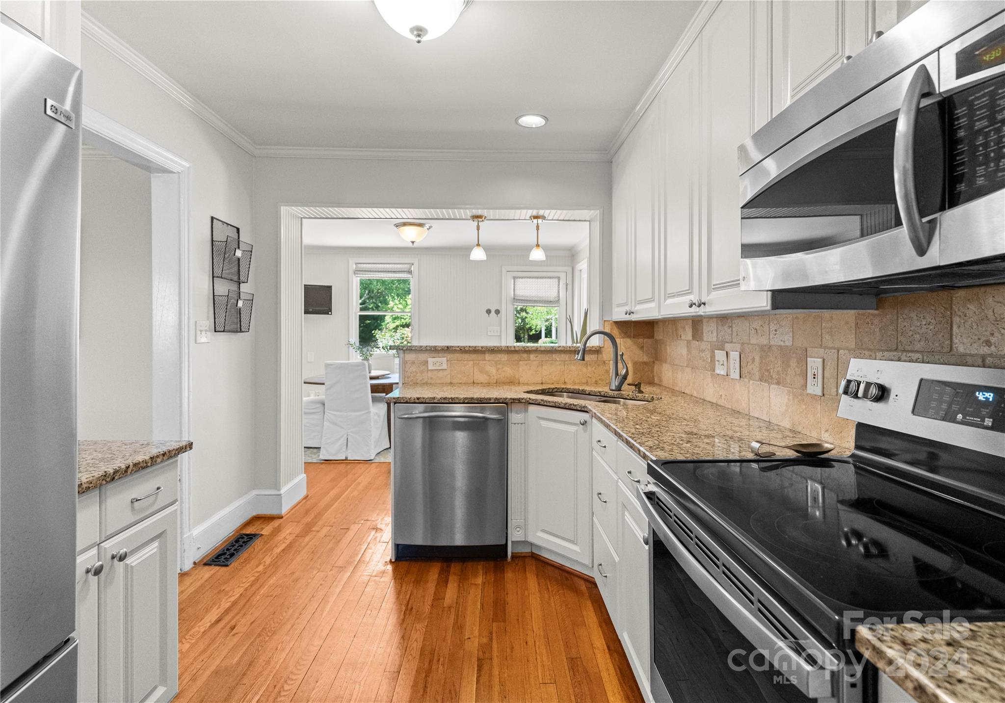 1108 Sedgefield Road Charlotte, NC 28209 - Photo 11 of 24 a kitchen with granite countertop stainless steel appliances and wooden cabinets
