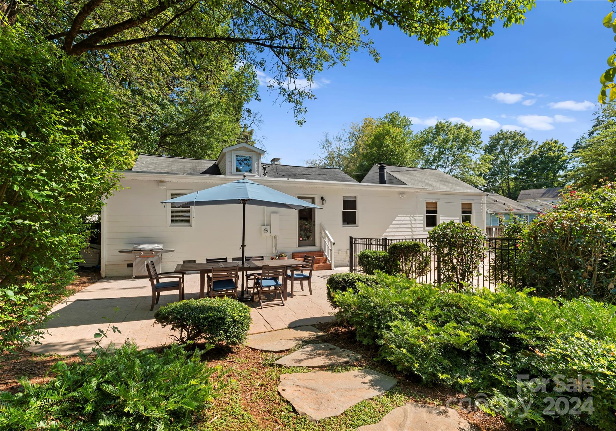 1108 Sedgefield Road Charlotte, NC 28209 - Photo 24 of 24 a view of a patio with table and chairs under an umbrella with potted plants