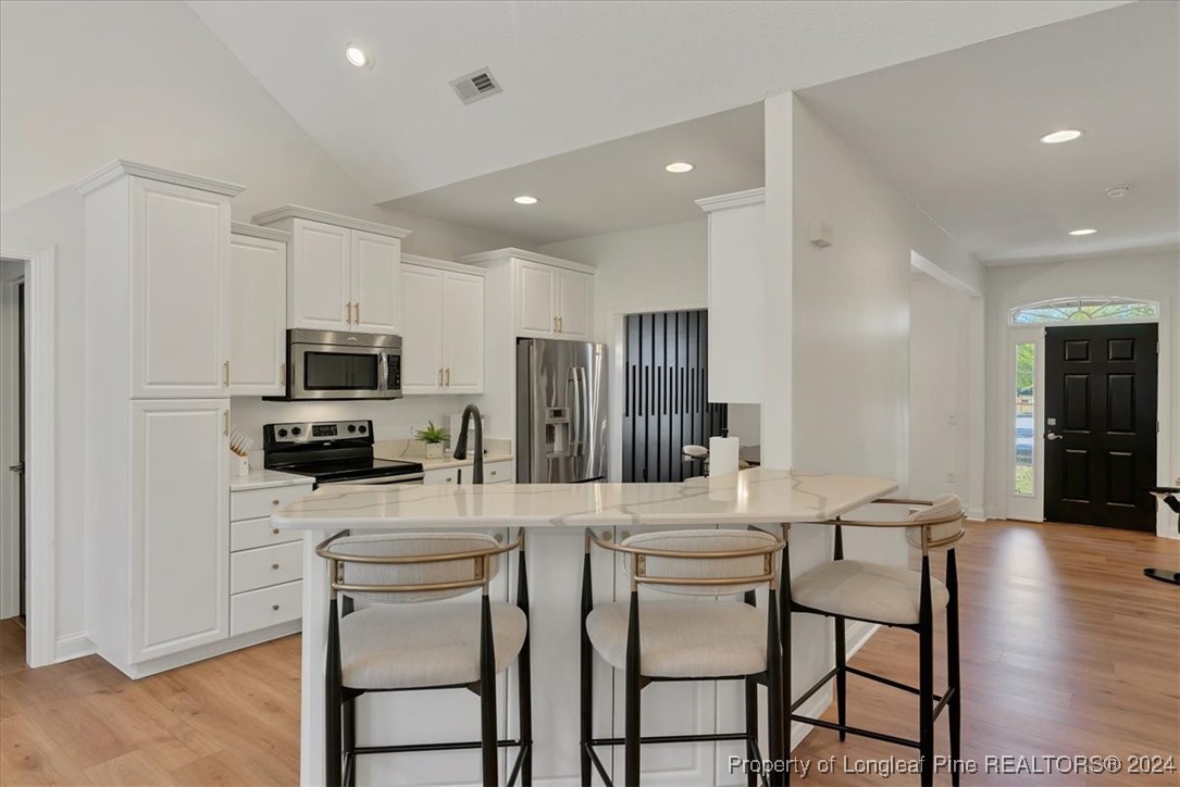 512 Maple Leaf Way Lumberton, NC 28358 - Photo 13 of 50 a kitchen with stainless steel appliances kitchen island granite countertop a dining table chairs refrigerator and sink