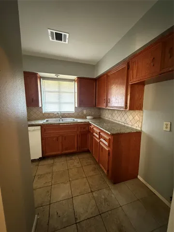 a kitchen with stainless steel appliances granite countertop a sink counter space cabinets and a window