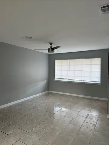 an empty room with windows and fan