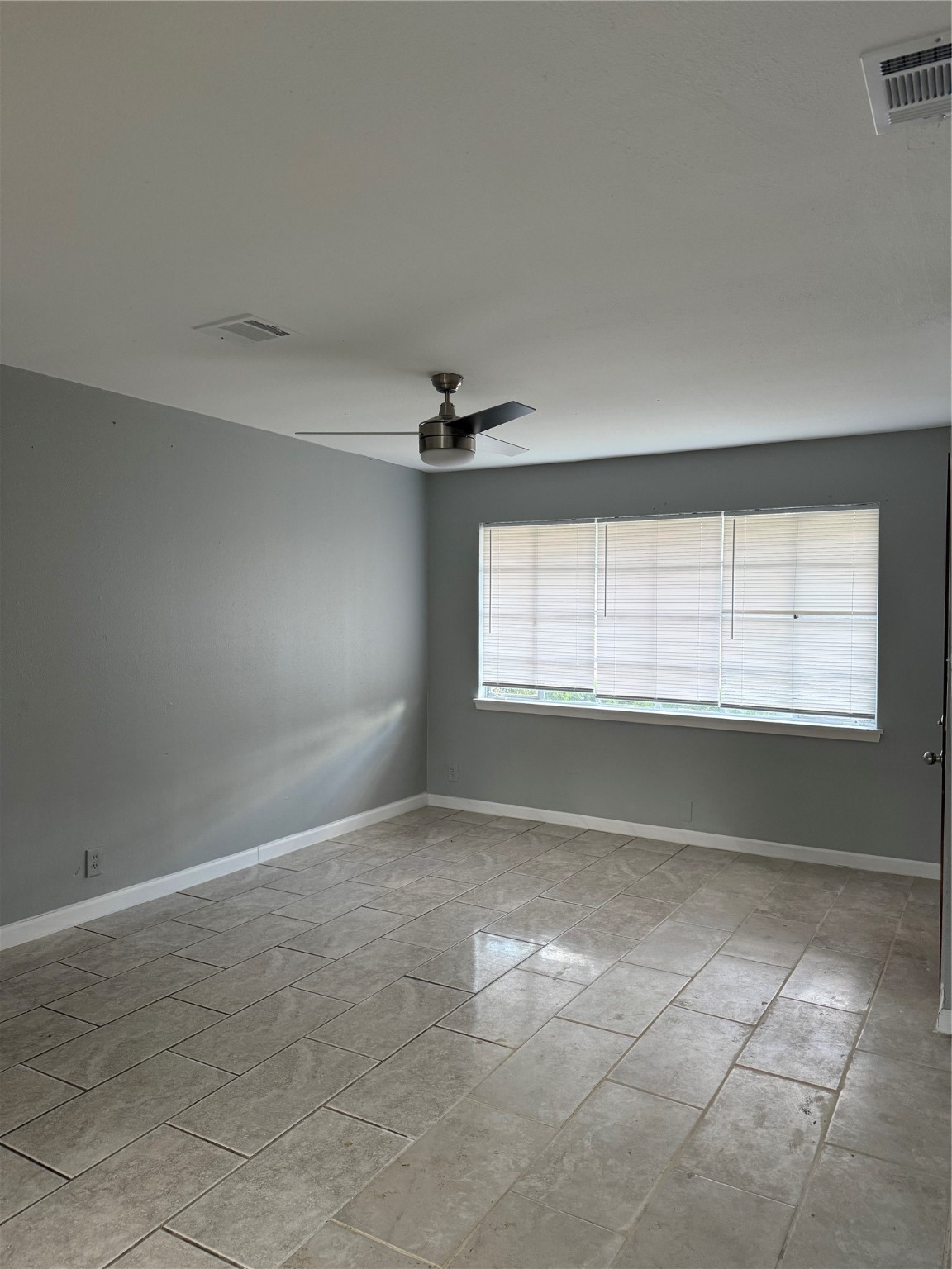9526 Hammerly Boulevard Houston, TX 77080 - Photo 6 of 16 an empty room with windows and fan