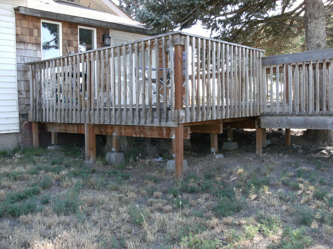541 Gurley Road Granger, WA 98932 - Photo 5 of 8 a view of a small house with a wooden deck and wooden fence