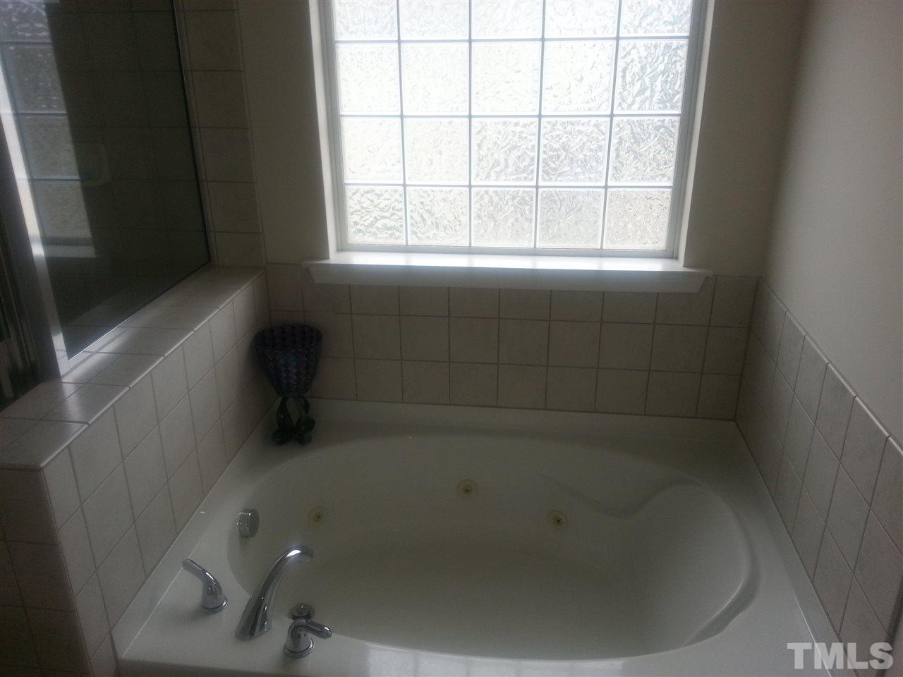 170 Ryder Cup Circle Raleigh, NC 27603 - Photo 14 of 23 a bath tub sitting in a bathroom next to a window
