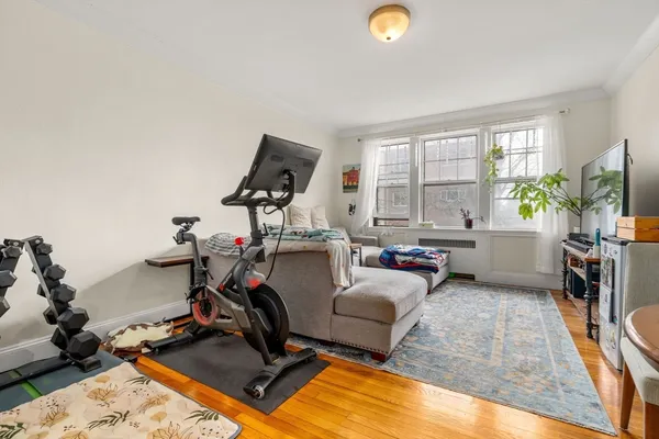 a living room with furniture a window and gym equipment