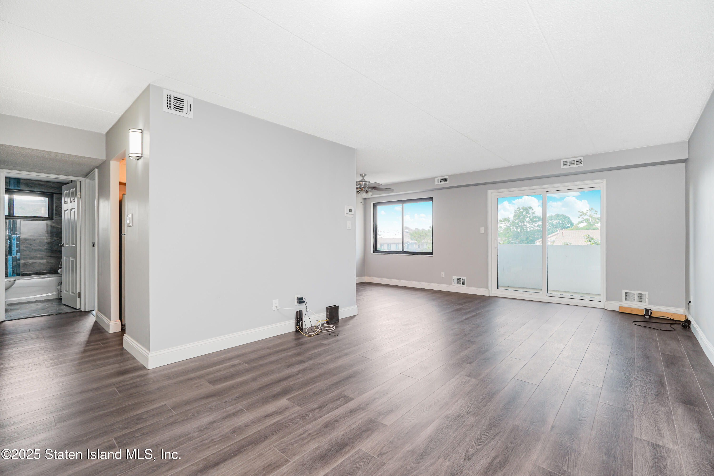 11 Windham Loop, Unit 3II Staten Island, NY 10314 - Photo 11 of 18 an empty room with wooden floor and windows