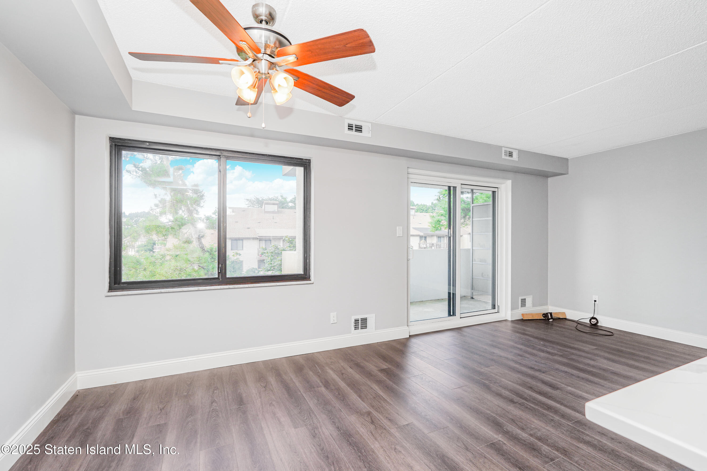 11 Windham Loop, Unit 3II Staten Island, NY 10314 - Photo 12 of 18 an empty room with wooden floor fan and windows