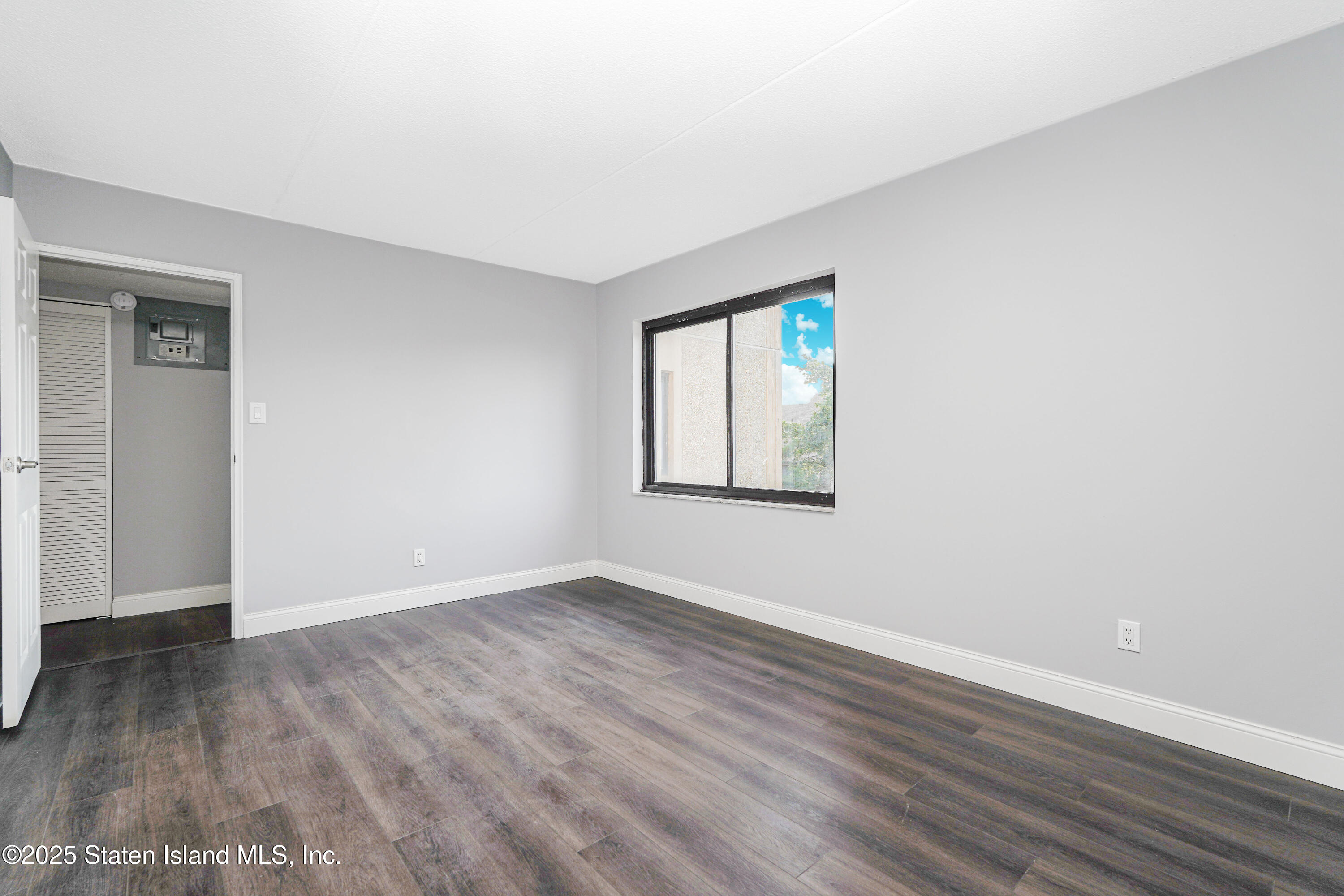 11 Windham Loop, Unit 3II Staten Island, NY 10314 - Photo 16 of 18 a view of an empty room with wooden floor and a window