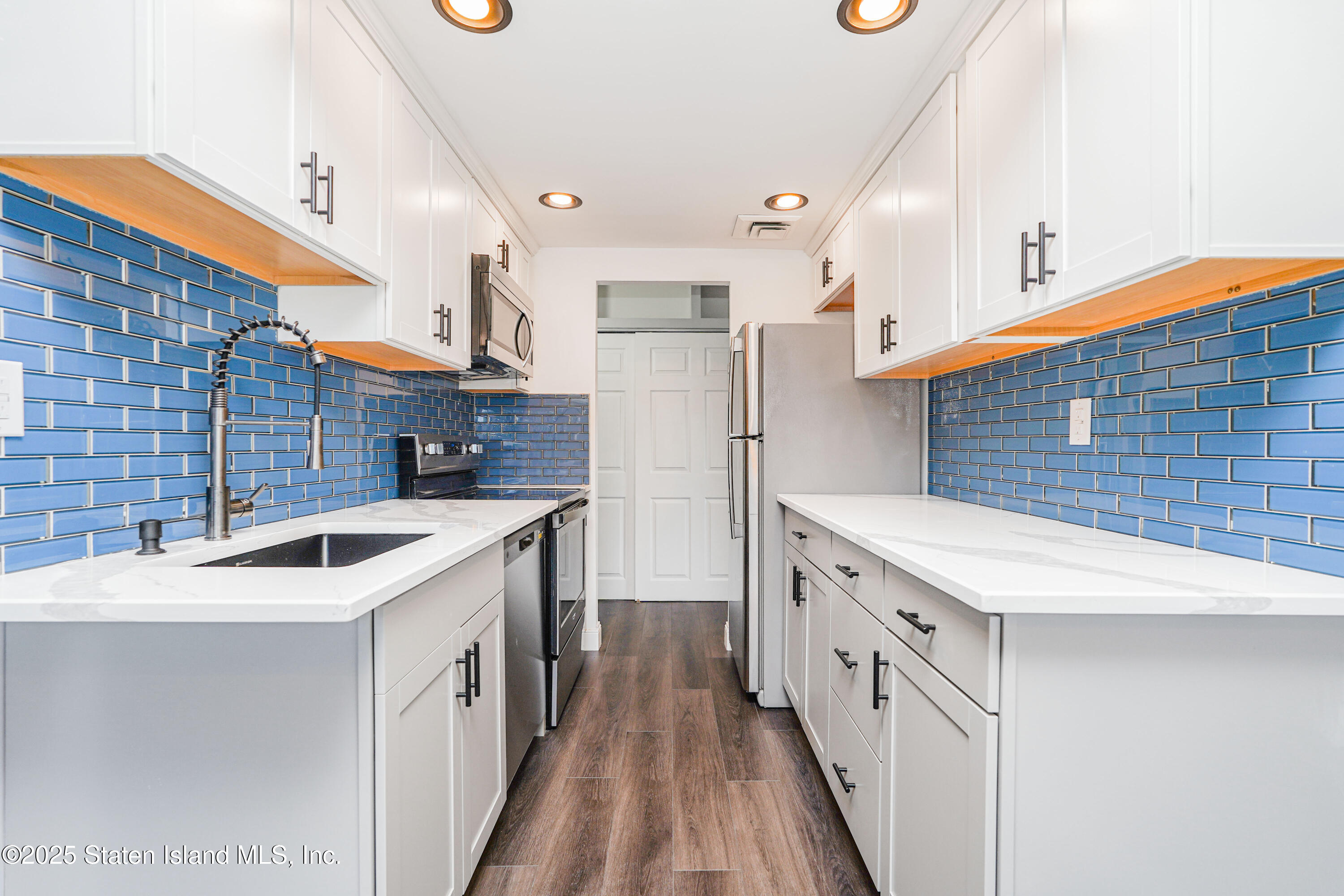 11 Windham Loop, Unit 3II Staten Island, NY 10314 - Photo 8 of 18 a kitchen with stainless steel appliances granite countertop a sink and dishwasher a oven with white cabinets