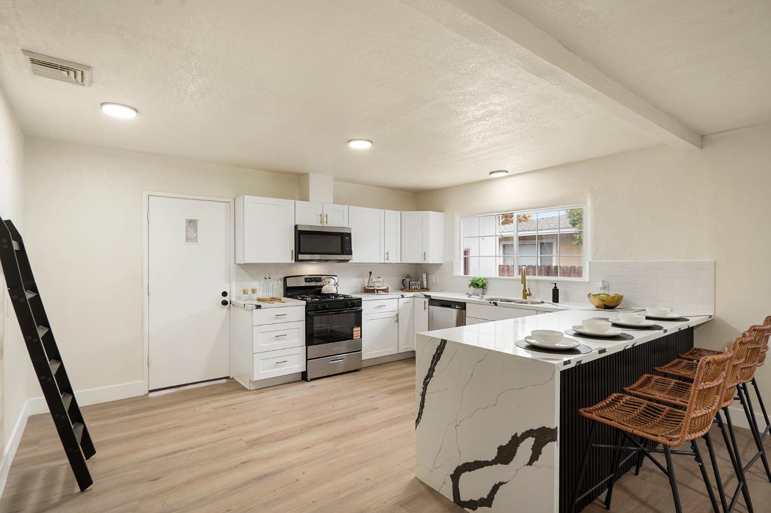 1417 Concord Avenue Modesto, CA 95350 - Photo 3 of 40 a kitchen with a sink a stove a refrigerator cabinets and wooden floor