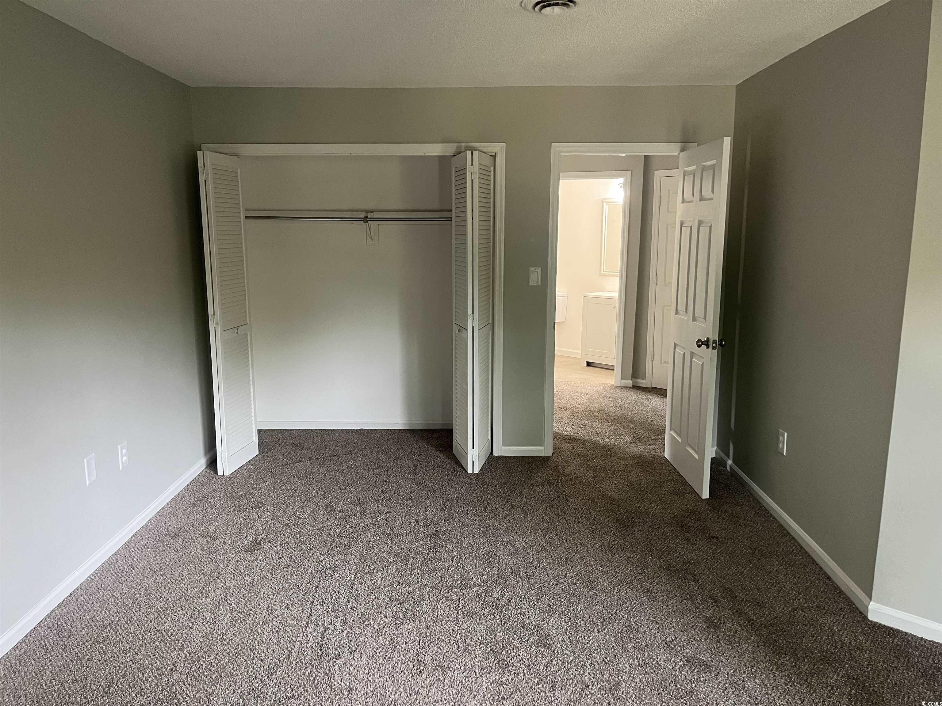 600 65th Avenue North, Unit 7 Myrtle Beach, SC 29572 - Photo 17 of 29 Unfurnished bedroom featuring carpet flooring, a closet, and a textured ceiling