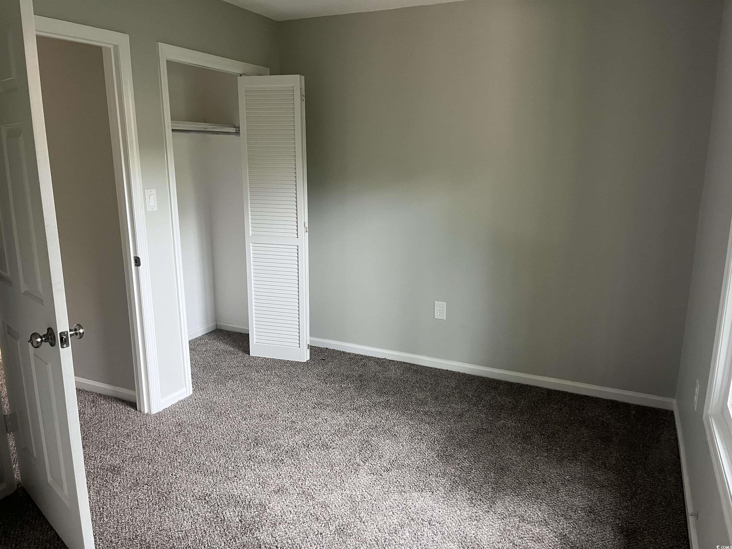600 65th Avenue North, Unit 7 Myrtle Beach, SC 29572 - Photo 19 of 29 Unfurnished bedroom with carpet flooring and a closet