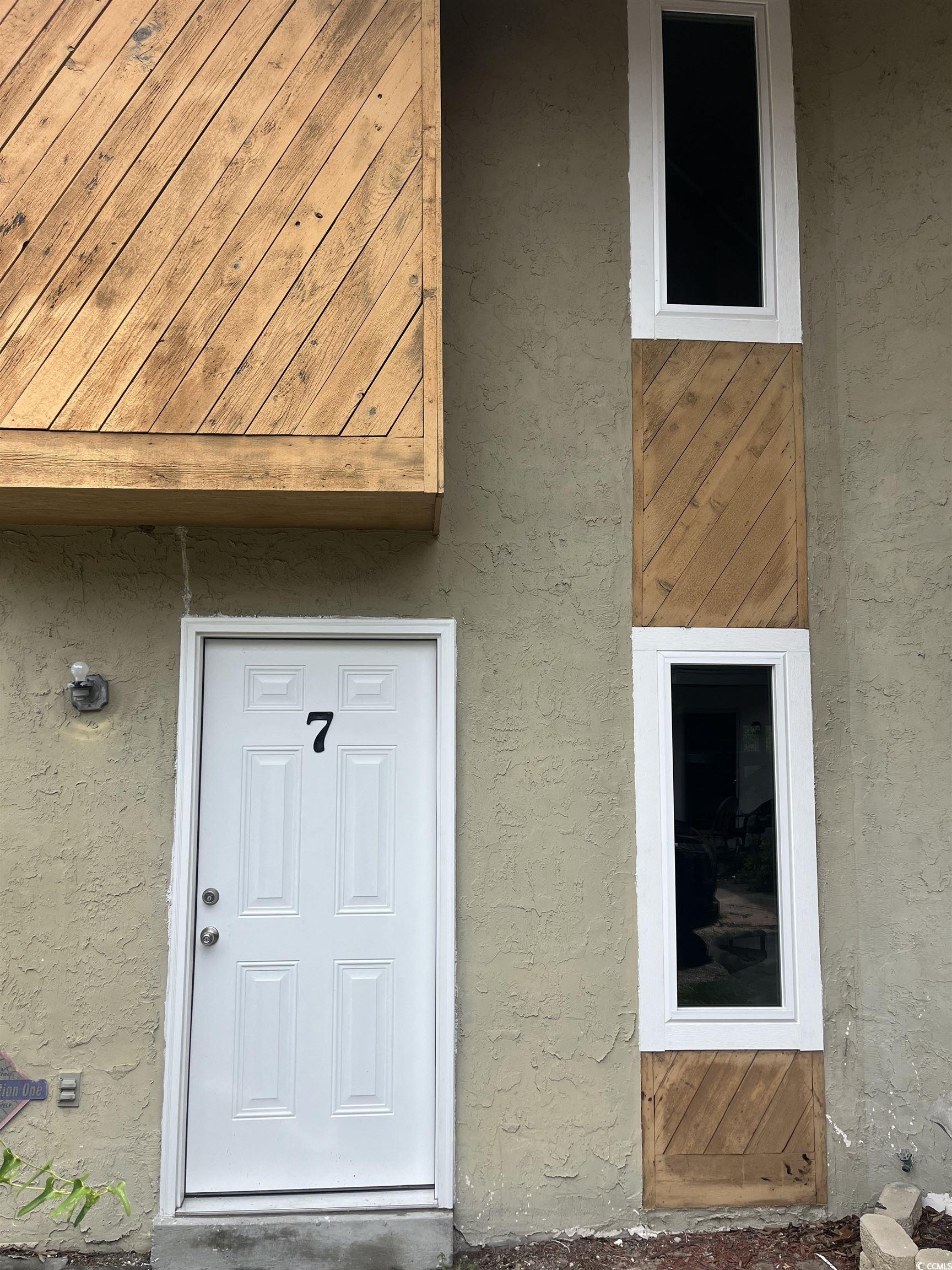 600 65th Avenue North, Unit 7 Myrtle Beach, SC 29572 - Photo 2 of 29 View of exterior entry featuring stucco siding
