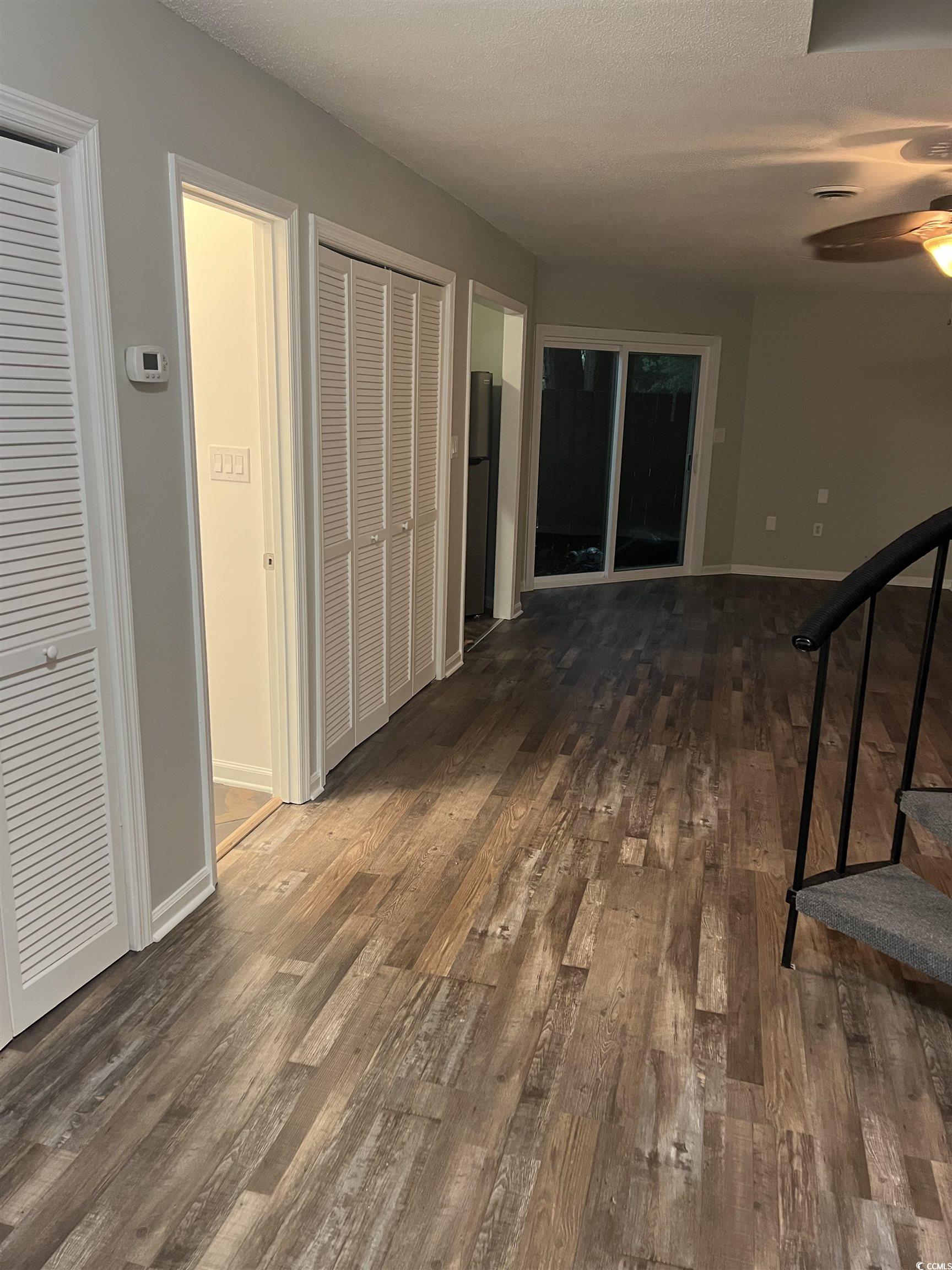 600 65th Avenue North, Unit 7 Myrtle Beach, SC 29572 - Photo 4 of 29 Hall with dark wood-type flooring, a textured ceiling, and stairs