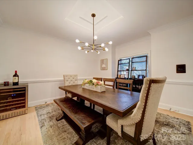 a view of a dining room and livingroom with furniture wooden floor a rug and a chandelier