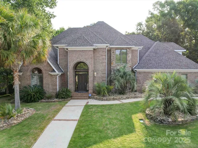 a front view of a house with a yard and potted plants