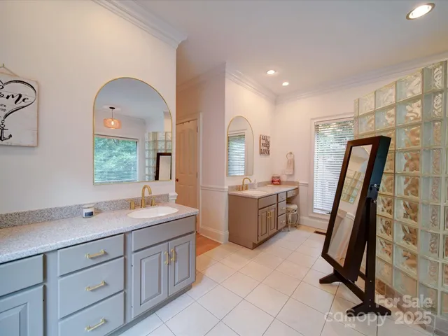 a bathroom with a double vanity sink a mirror a bathtub and a shower