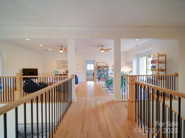 a view of a hallway with wooden floor and stairs