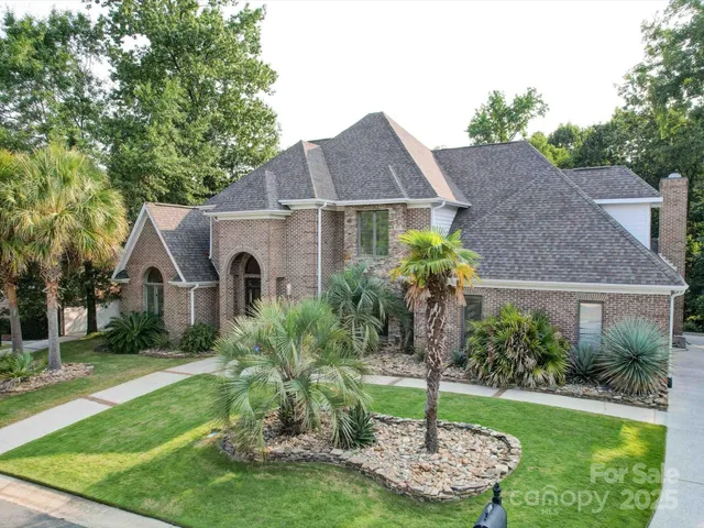 a front view of a house with a yard and green space