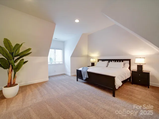 a spacious bedroom with a bed and a potted plant