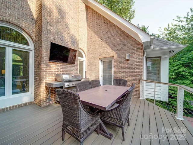 a view of a patio with table and chairs with wooden floor and fence