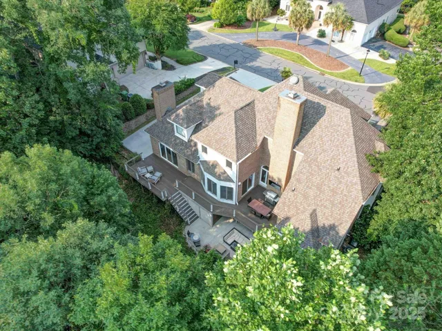 an aerial view of a house with a yard and trees