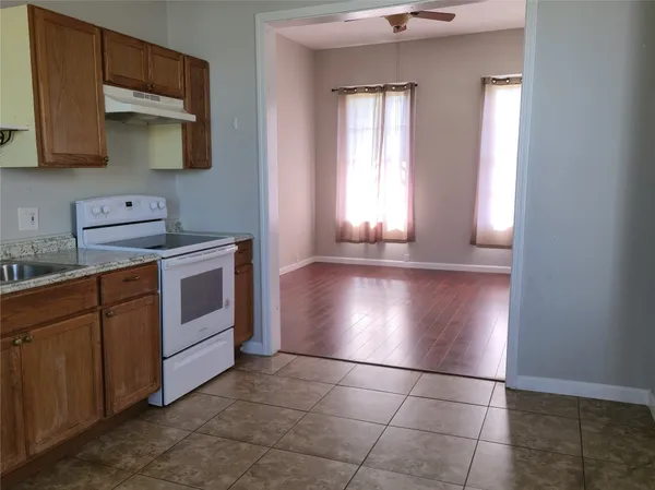 a kitchen with granite countertop a stove a sink and a microwave