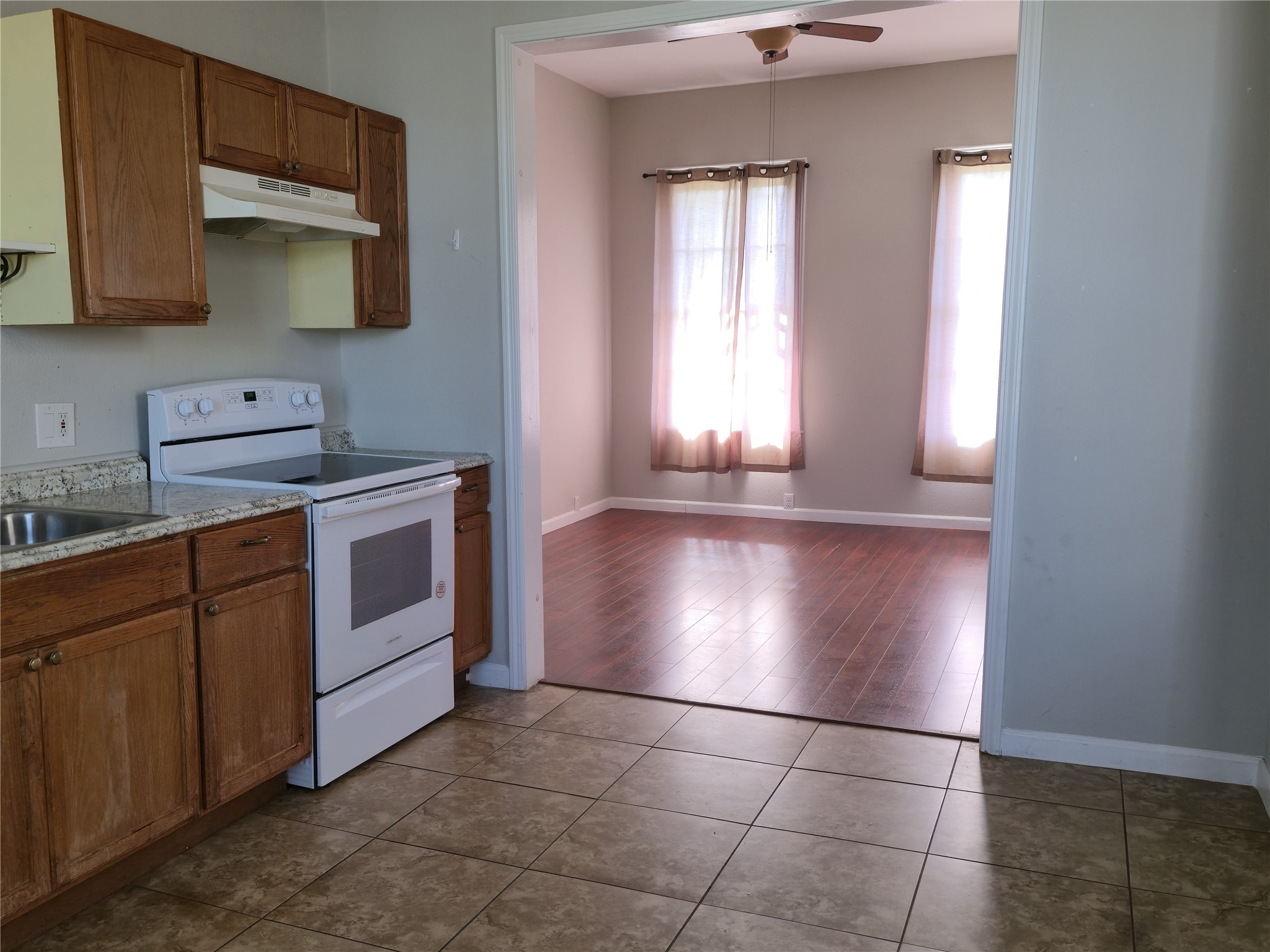 1614 Market Street, Unit 2 Galveston, TX 77550 - Photo 12 of 22 a kitchen with granite countertop a stove a sink and a microwave