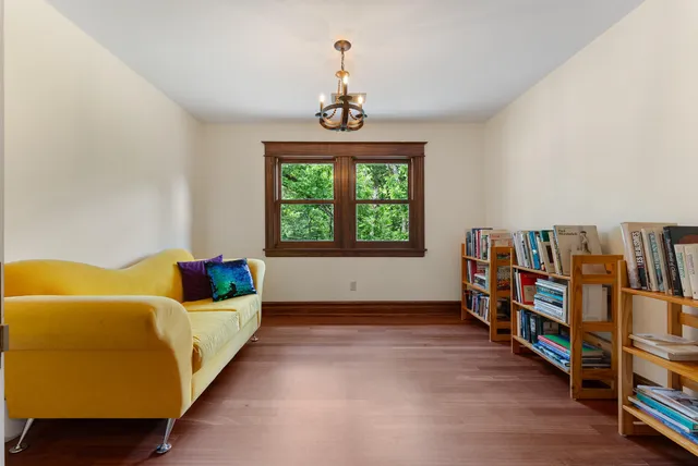 a living room with a bed and a book shelf