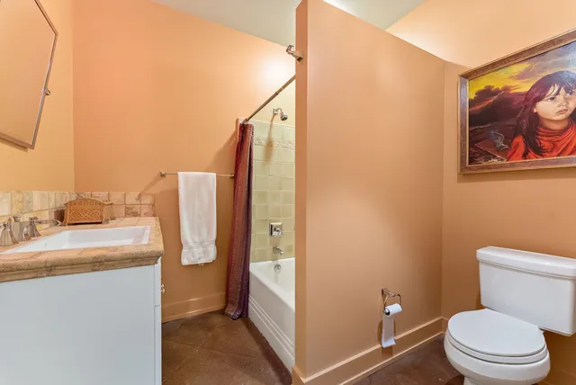 a bedroom with a bed and a lamp on dresser