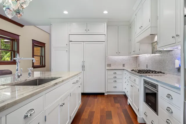 a kitchen with granite countertop white cabinets and white appliances