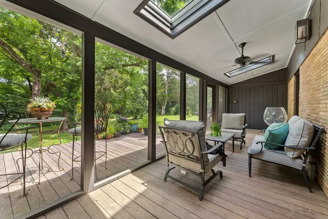 a living room with patio furniture and a floor to ceiling window