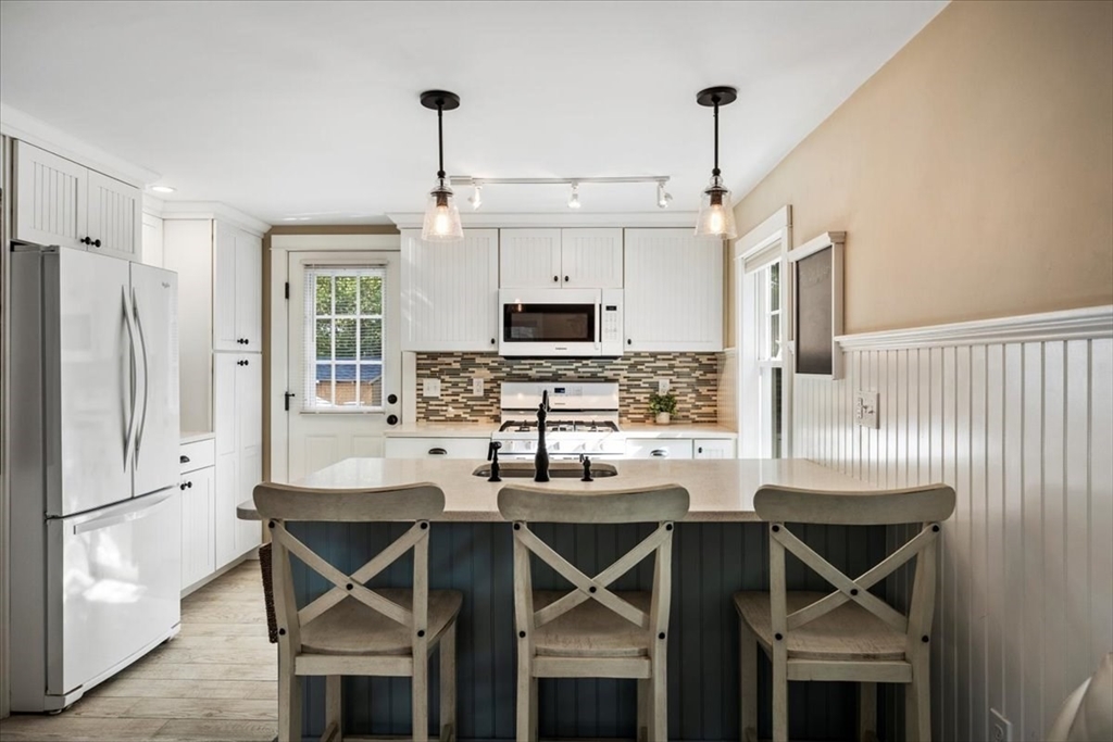 2 River Road Pocasset, MA 02559 - Photo 11 of 37 a kitchen with kitchen island a dining table chairs and refrigerator