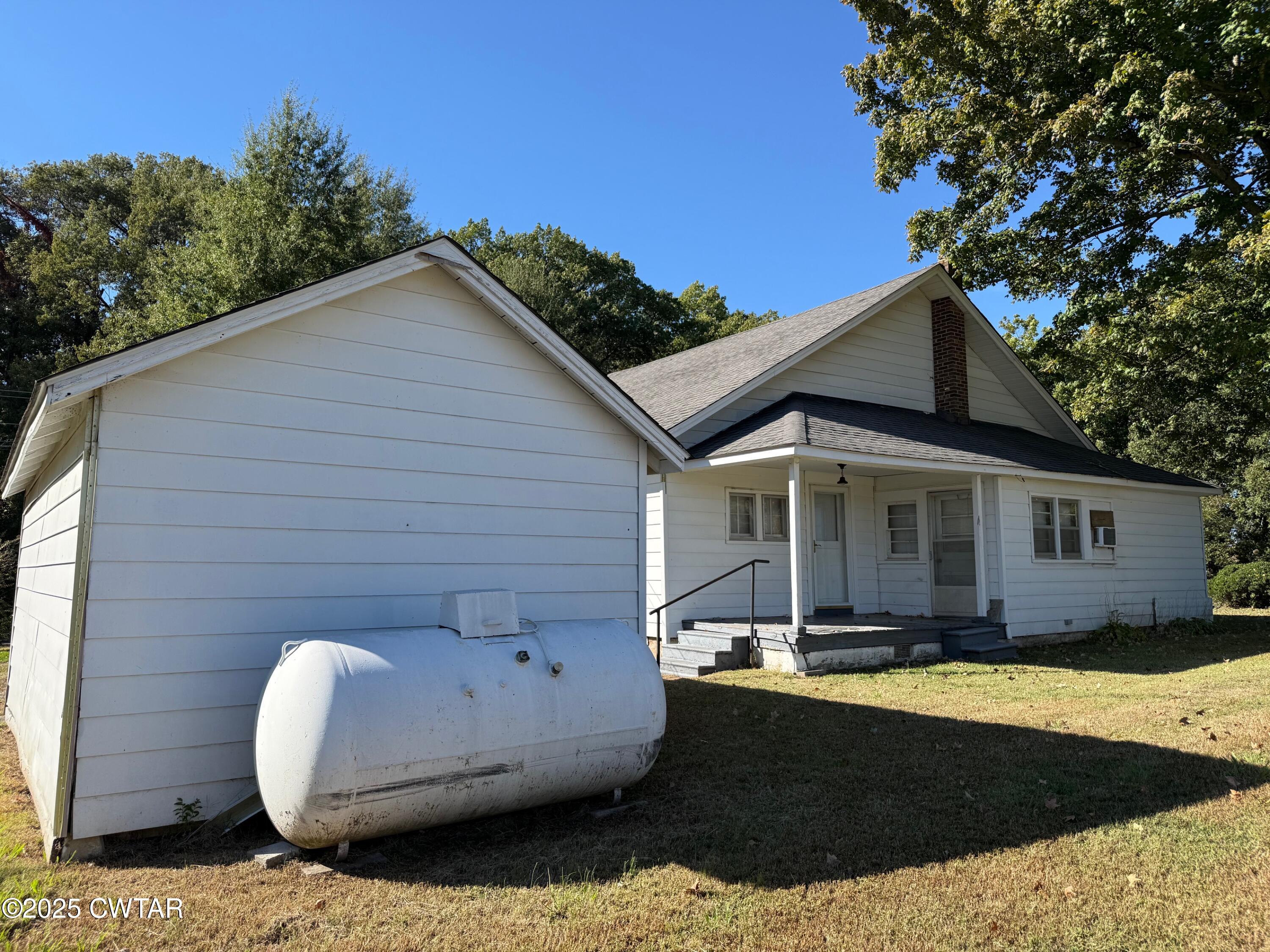 3794 Roellen Newbern Road Newbern, TN 38059 - Photo 17 of 25 a view of a white house with a small yard and a large tree