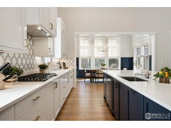 a large white kitchen with lots of counter space and windows