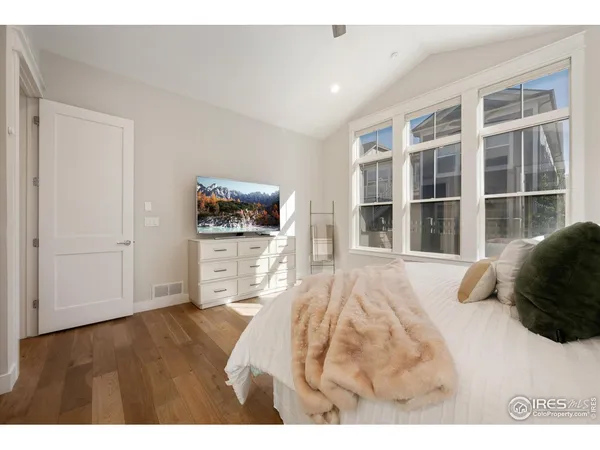 a bedroom with a bed tv and a window
