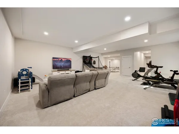a living room with furniture a flat screen tv and gym equipment