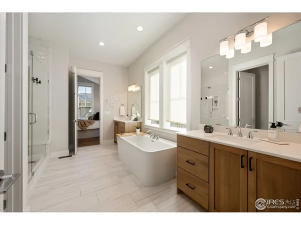 a bathroom with a double vanity sink mirror and bathtub