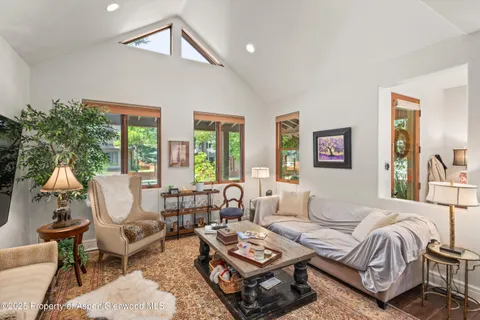 a kitchen with stainless steel appliances kitchen island granite countertop a stove a sink a dining table and chairs with wooden floor